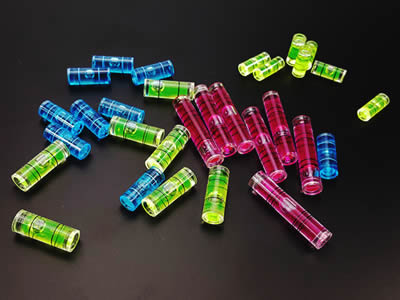 There are four plastic tubular bubble level vials of different color.