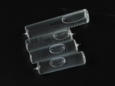 Four straight glass tubular bubble level vials on the black background.