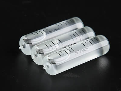 Three glass tubular bubble level vials with tips on the black background.